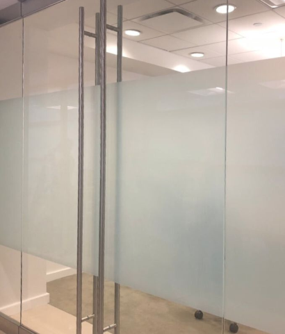 Frosted glass film is used to provide privacy on the glass doors of a conference room in a corporate office.