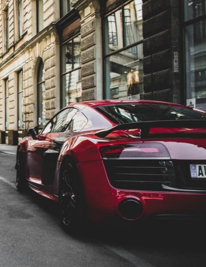 A red Audi R8 with window tinting on the glass and tail lights.